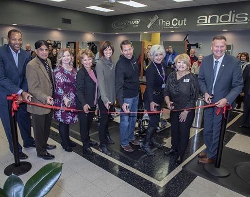 Large version of Laura and Matt Andis posing with seven other men and women at a ribbon cutting ceremony for The Cut school.